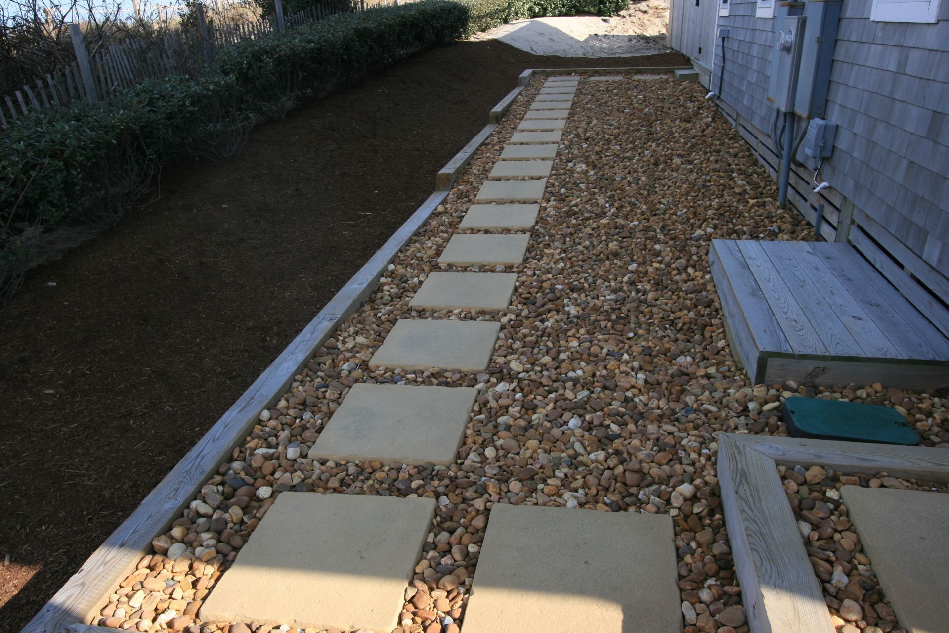 Eight inch square pavers embedded in number 3 rock.