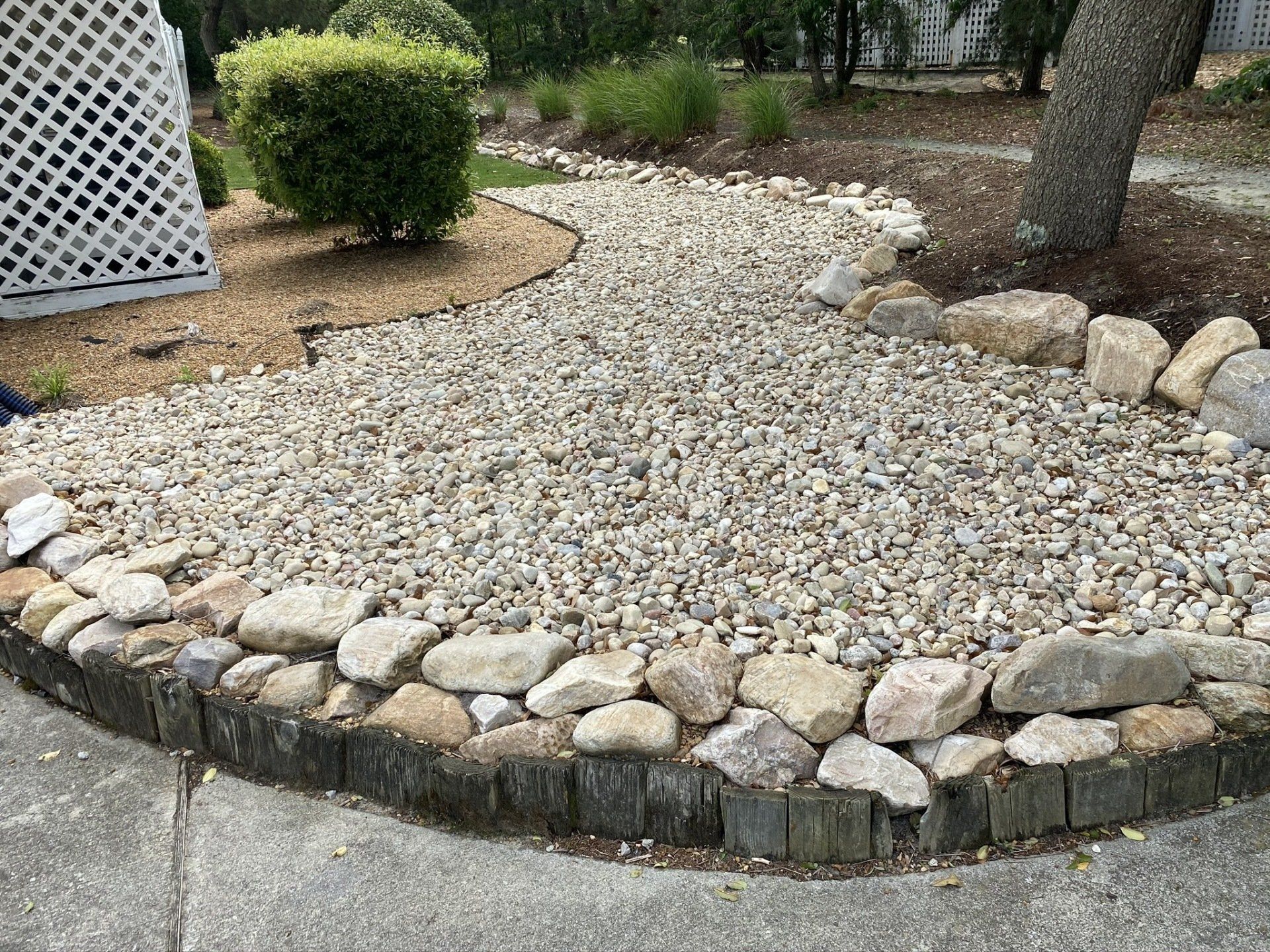 Large river rock borders a rock bed of  number 3 rock pathway.