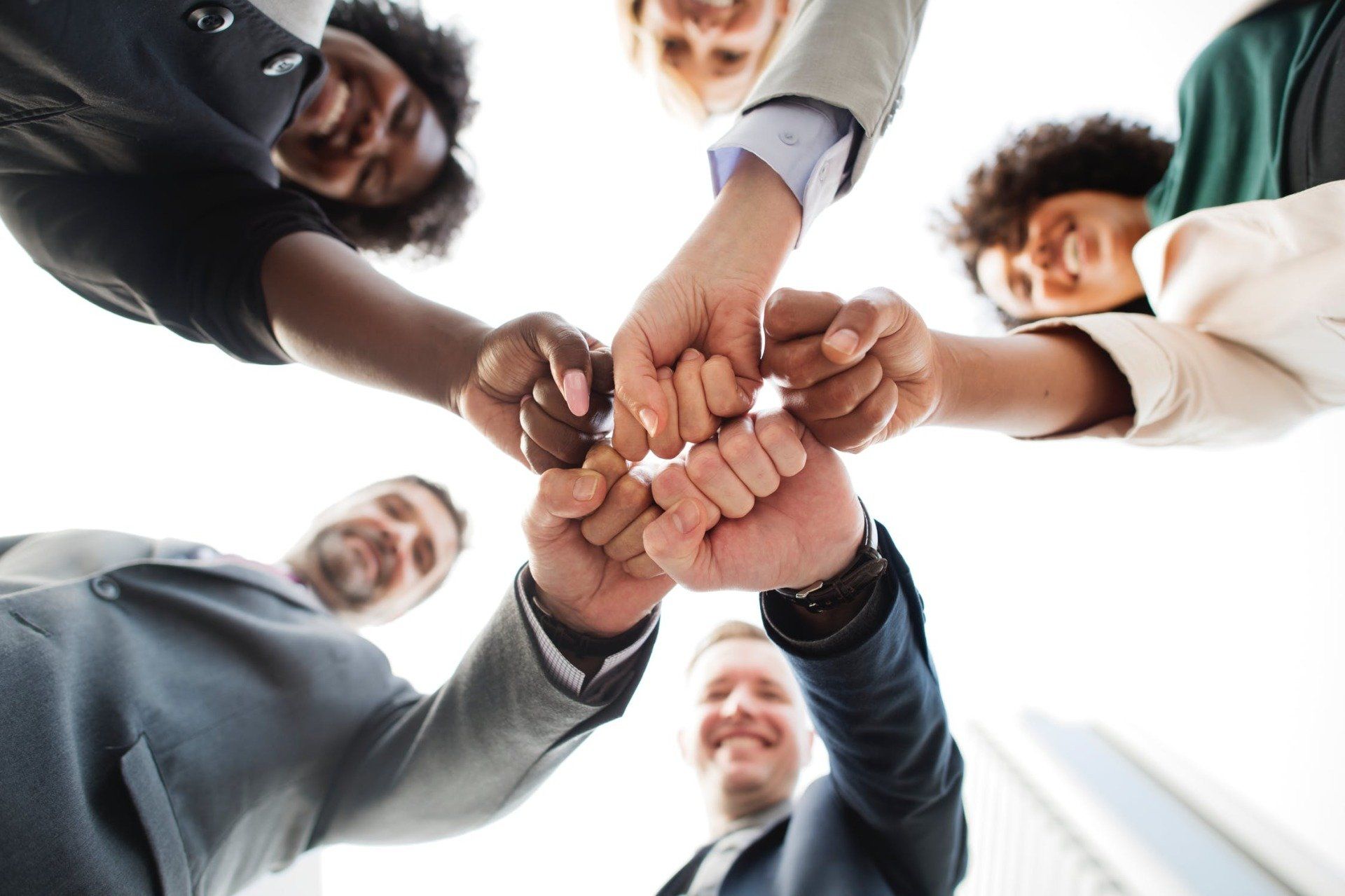 A group of people are putting their hands together in a circle.