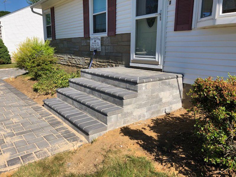 multi step stoop made of grey stone leading front door