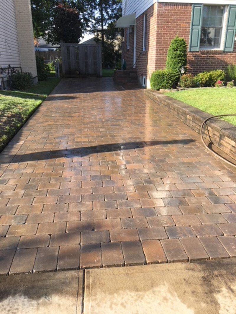 wet brown stone long driveway on side of house