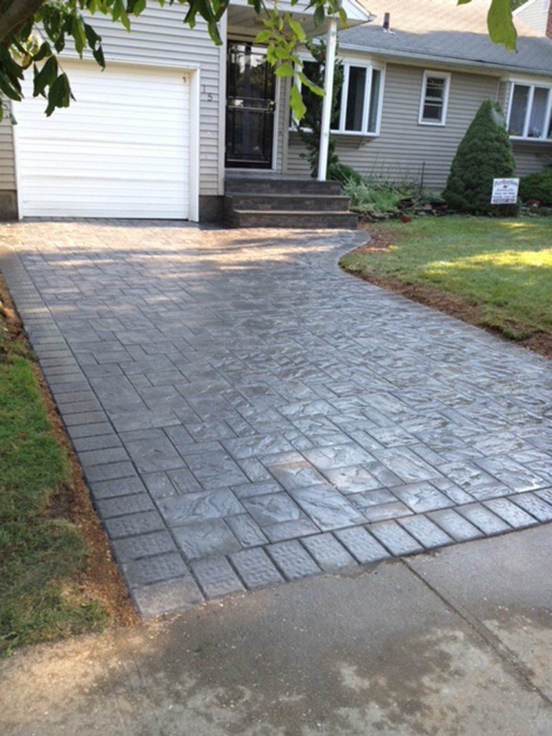 wet grey stone driveway leading to garage