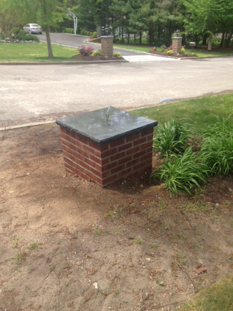 small red brick light post with black slate top