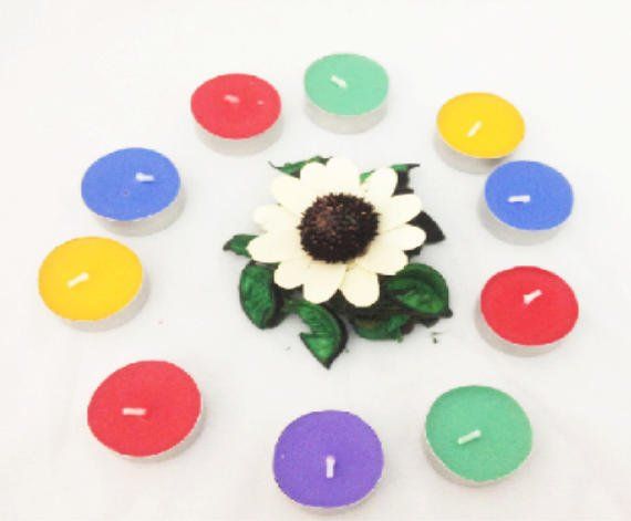 A circle of candles with a flower in the middle