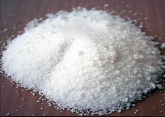 A pile of white powder is sitting on a wooden table.