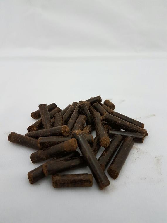 A pile of brown sticks on a white surface.
