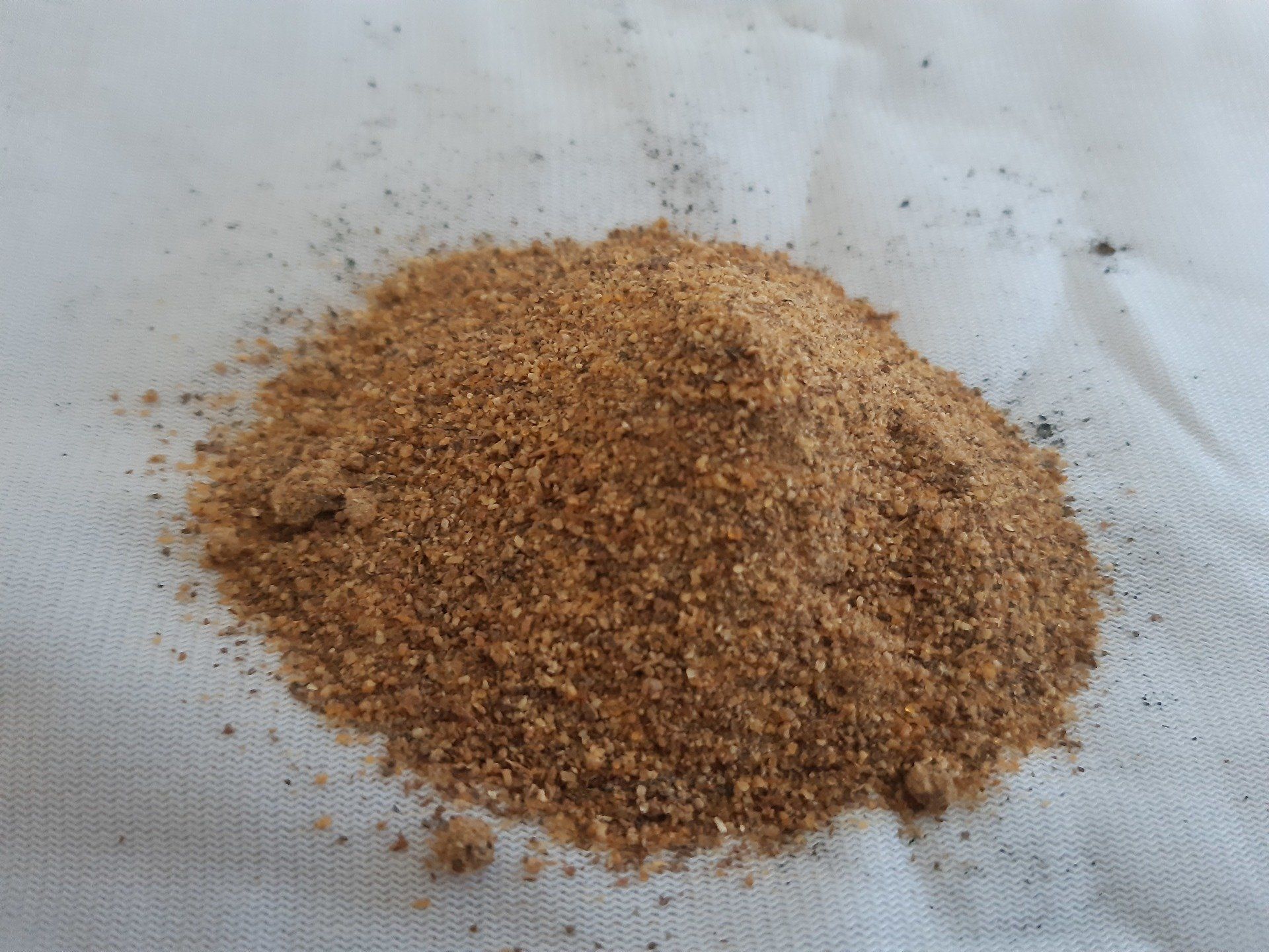 A pile of brown powder is sitting on a white cloth.