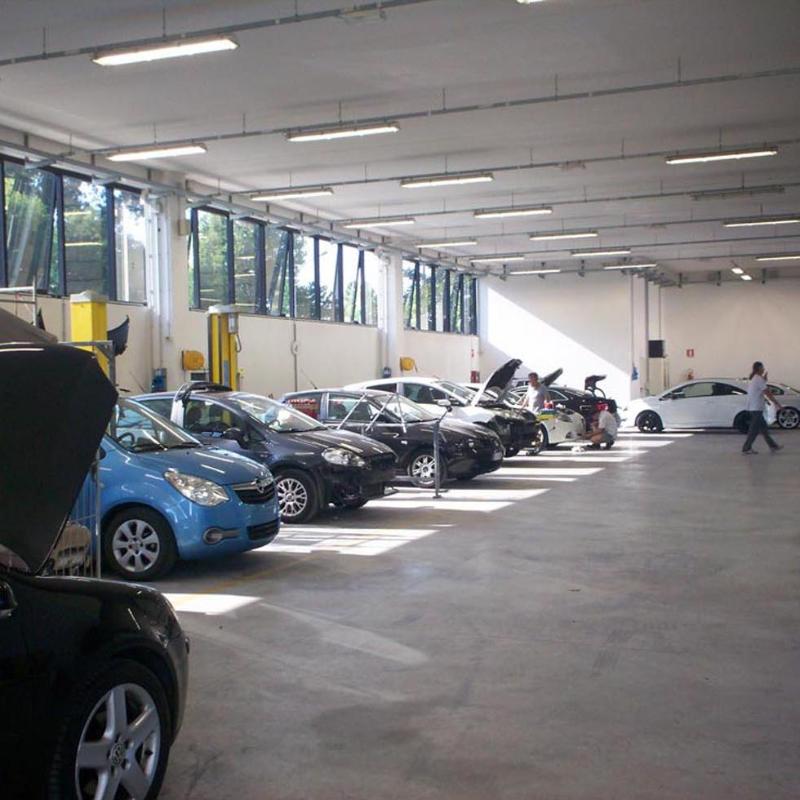 vista laterale fila di macchine durante riparazione in una officina auto