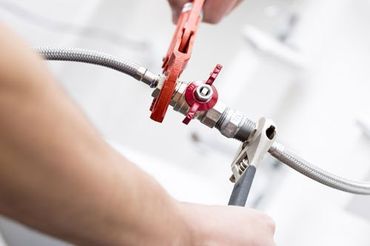 a person is fixing a pipe with a wrench .