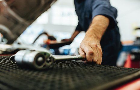 Auto Repair — Mechanic Picking Up A Ratchet Spanner in Agawam, MA Auto Repair — Mechanic Picking Up A Ratchet Spanner in Agawam, MA