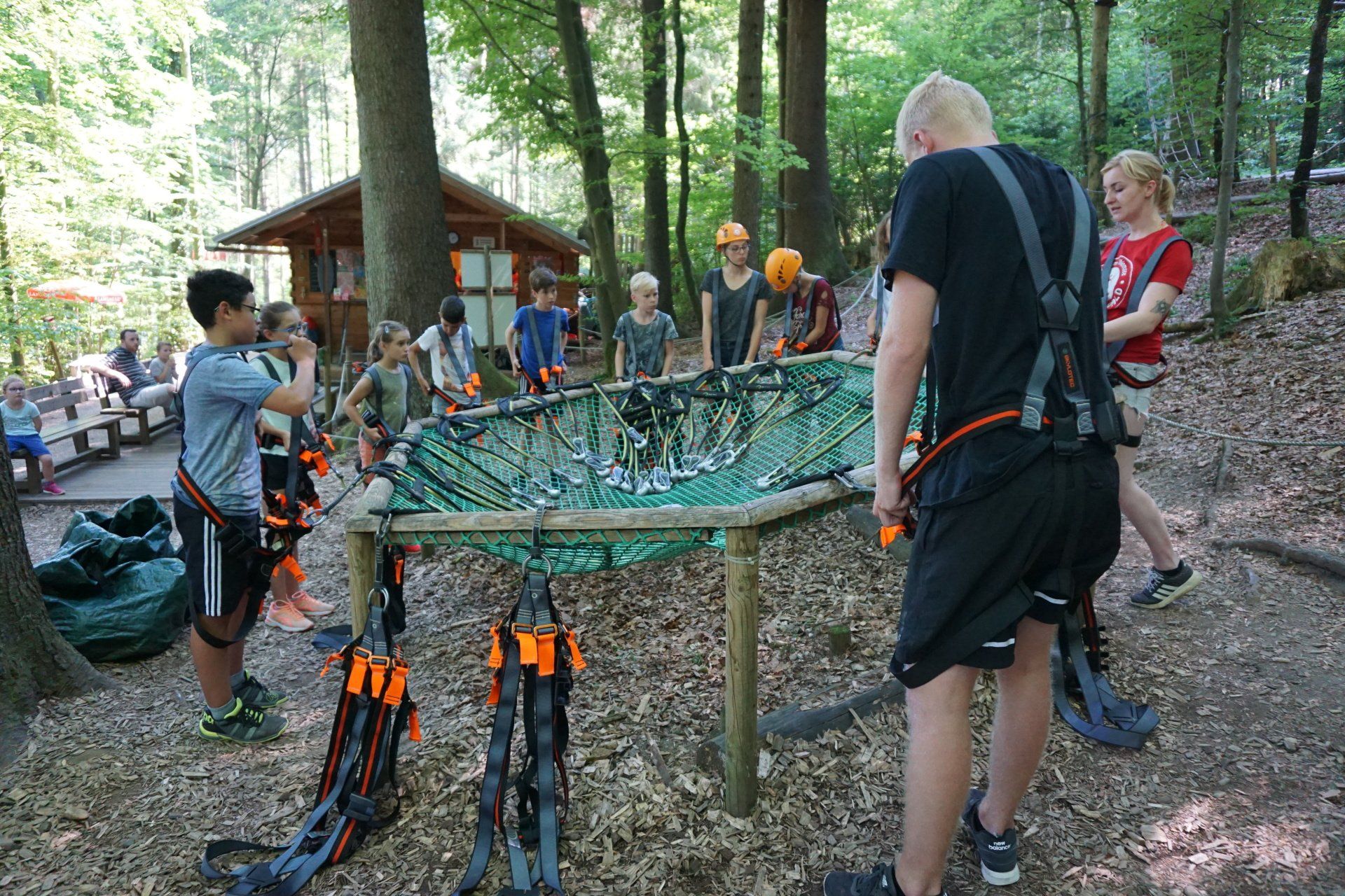 Eine Gruppe von Menschen steht um einen Tisch im Wald.
