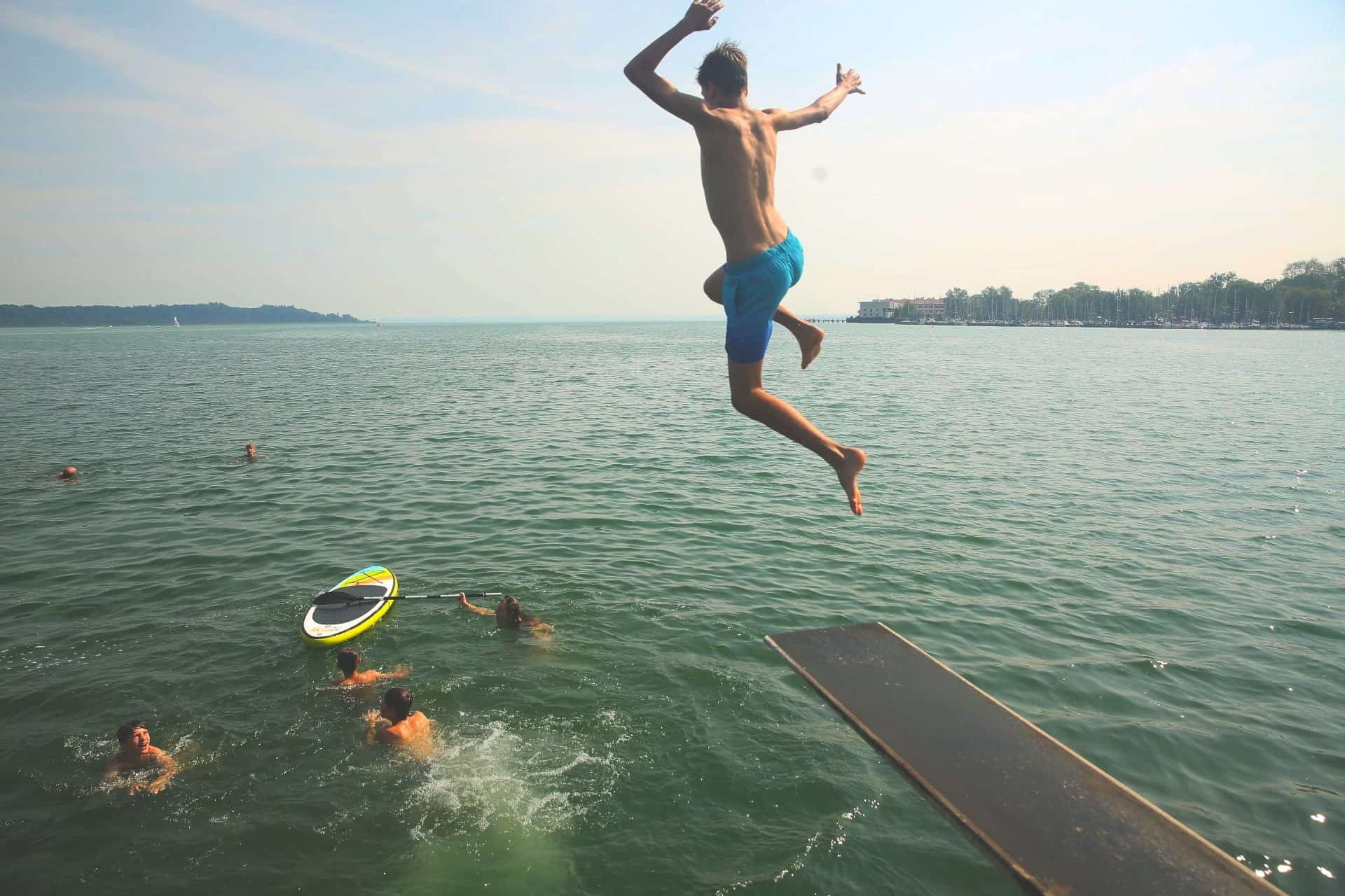 Ein Mann springt von einem Sprungbrett ins Wasser