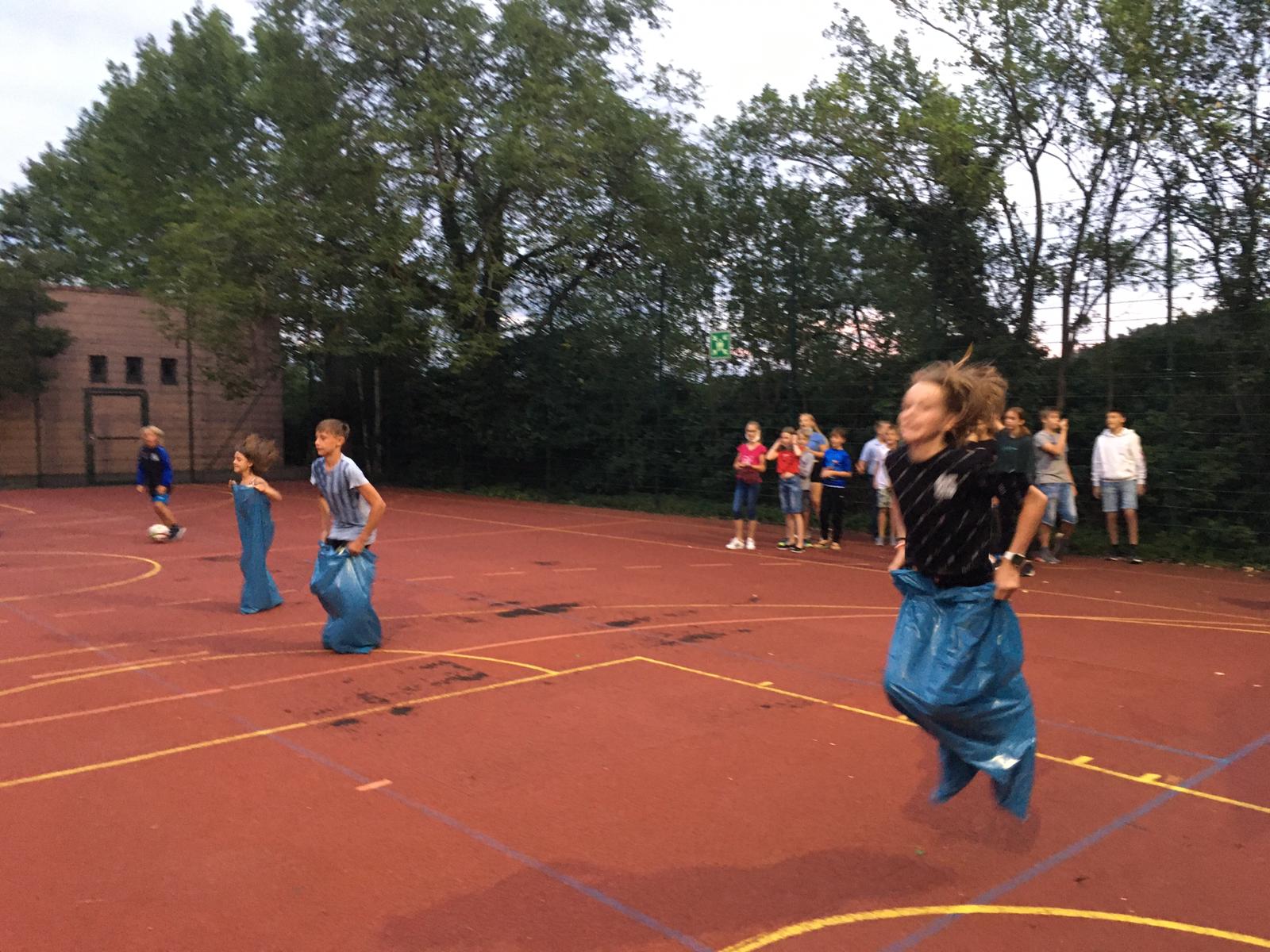 Eine Gruppe Kinder spielt ein Spiel auf einem Basketballplatz.