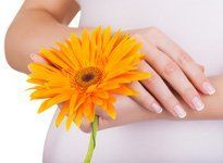 A pregnant woman holding a flower