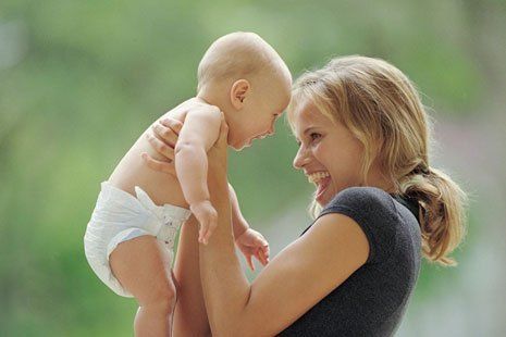 A mother lifting her baby