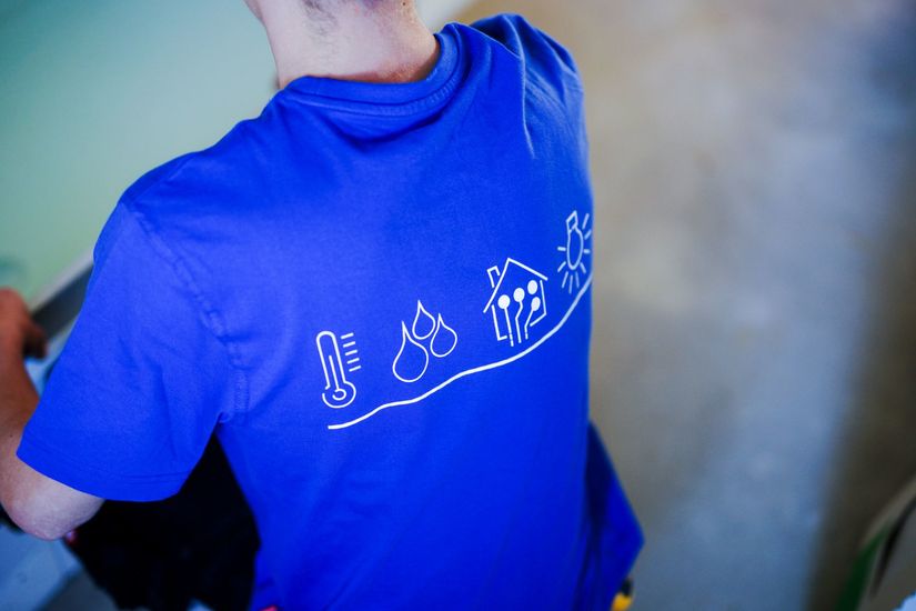 Eine Person, die ein blaues T-Shirt mit Loerts-Symbolen auf dem Rücken trägt