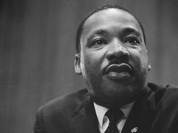 A black and white photo of martin luther king jr. in a suit and tie.