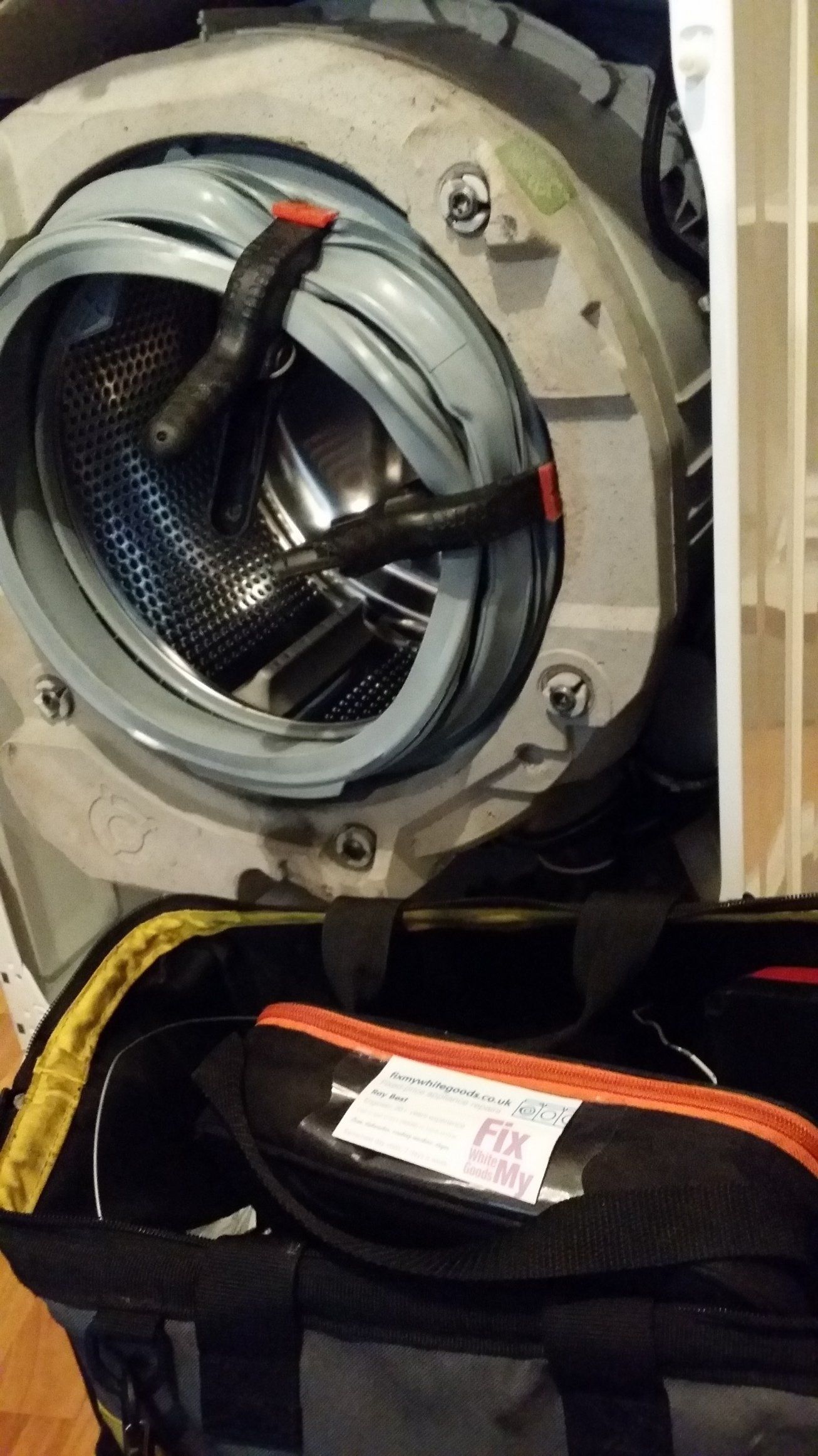 New door seal being fitted. Washing machine door seal being replaced