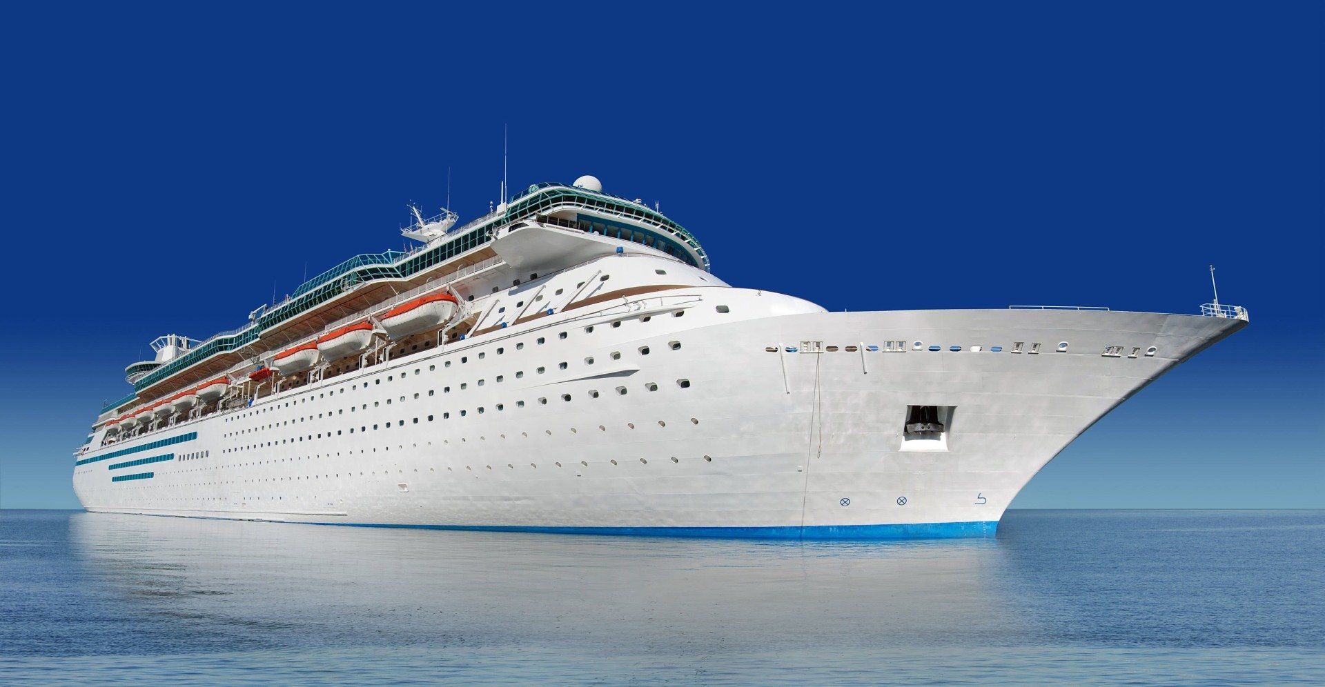 Weißes Kreuzfahrtschiff auf blauem Wasser. Sonniger Tag mit klarem, blauem Himmel.