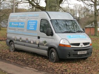 A company vehicle parked near a tree