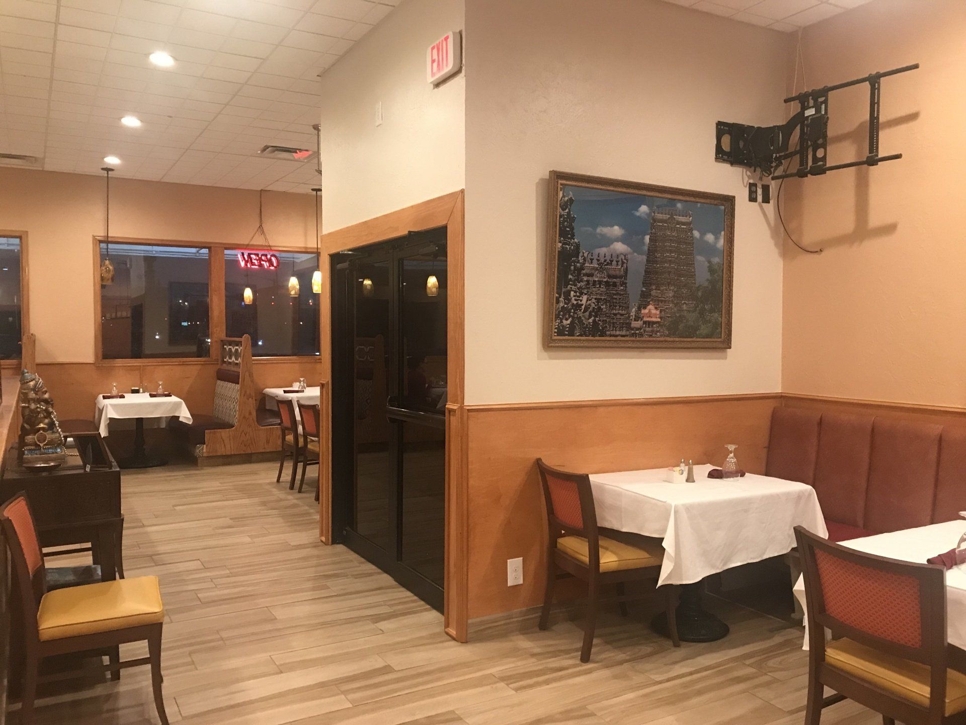 A restaurant with tables and chairs and a picture on the wall.