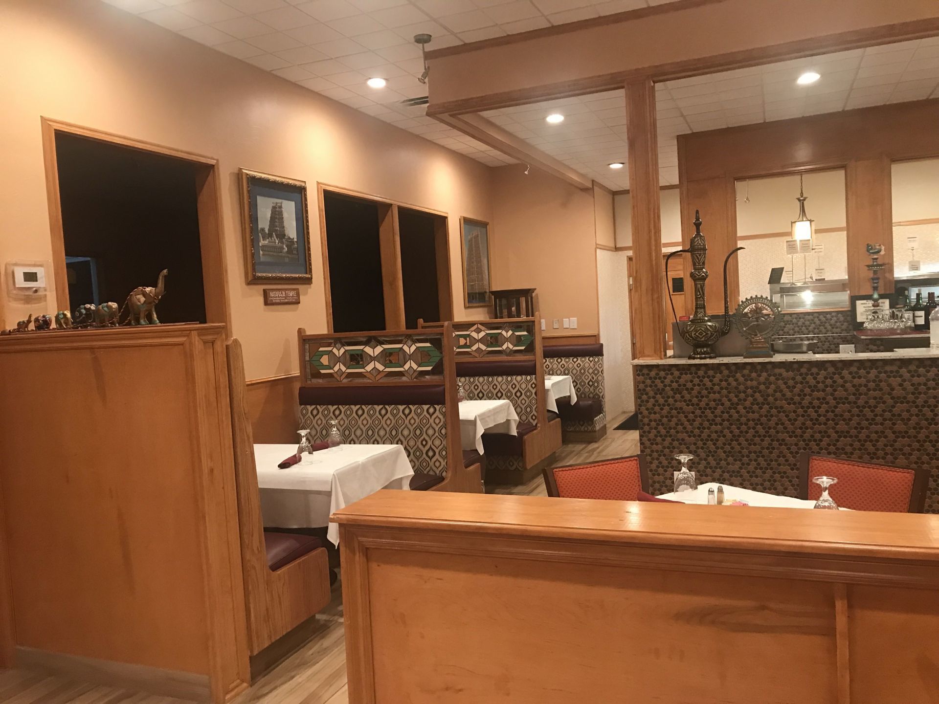 The inside of a restaurant with tables and chairs and a counter.