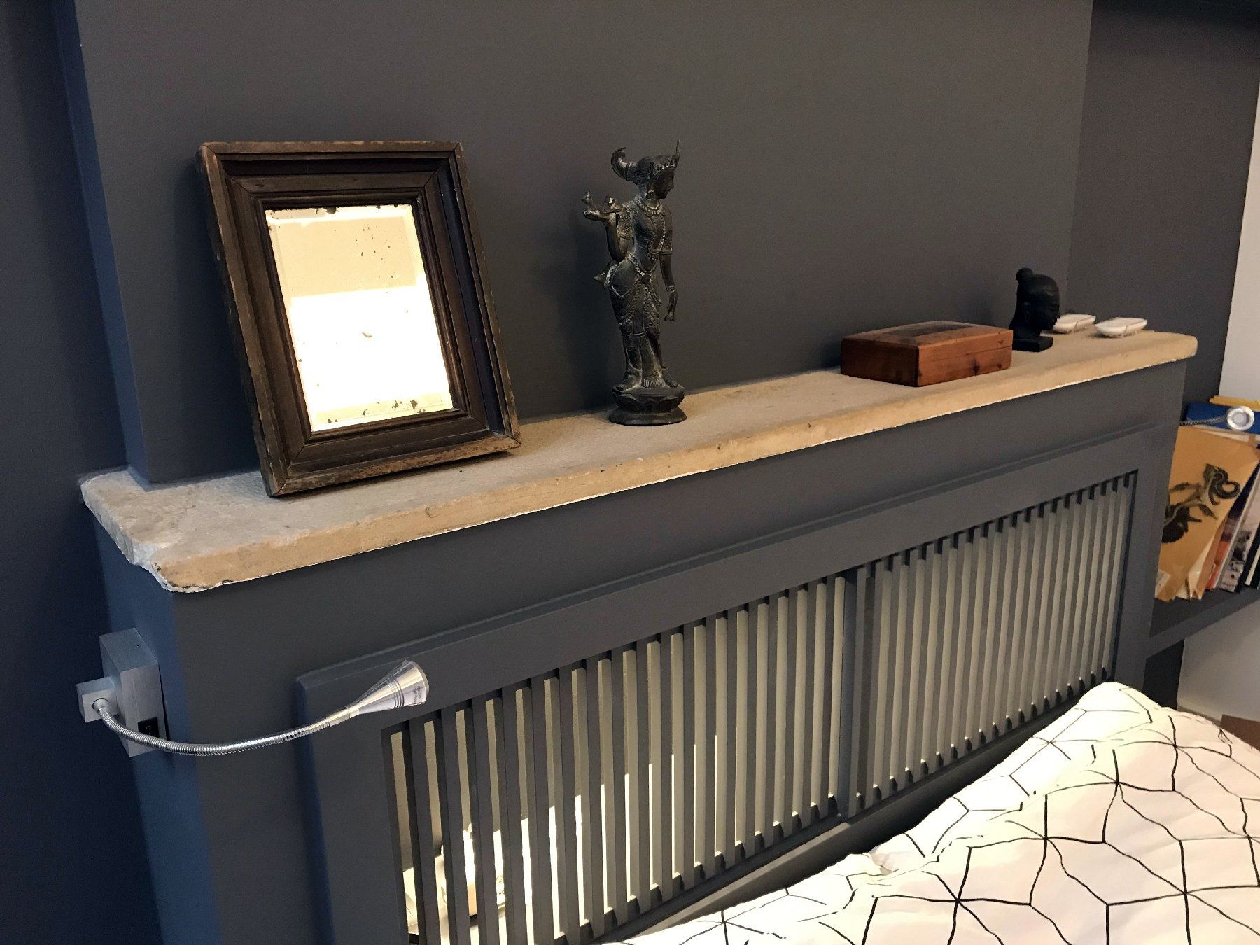 Radiateur du salon avec étagère blanche sur la cheminée, photo encadrée, décoration et canapé à motifs à proximité