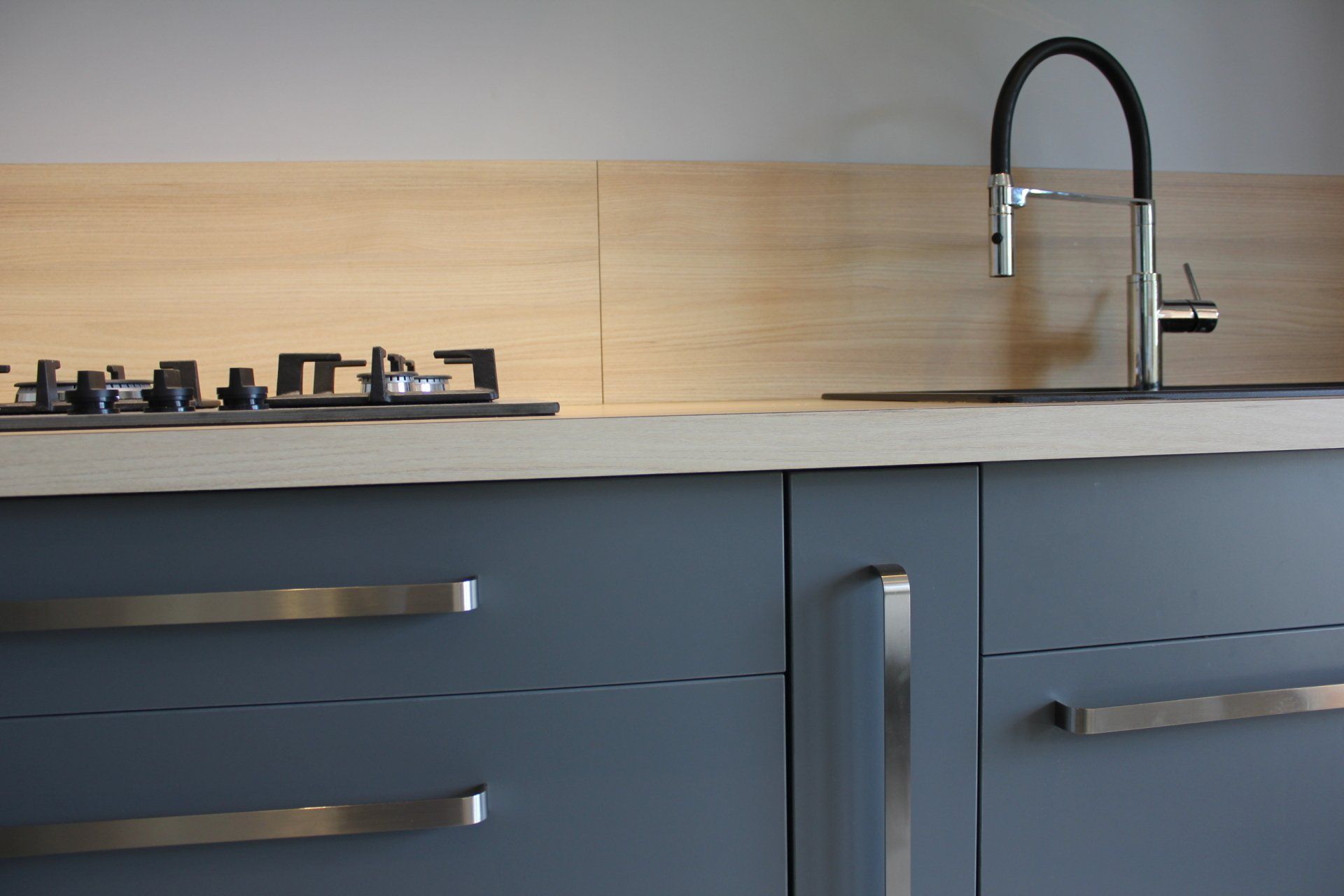 Cuisine moderne avec armoires bleues, plaque de cuisson au gaz et robinet en acier inoxydable