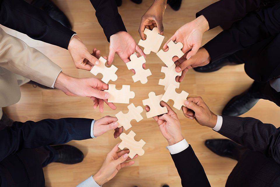 professionals holding puzzle pieces in hand