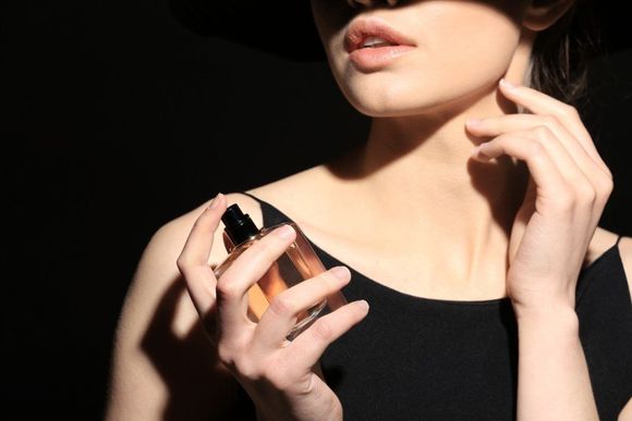 donna con bottiglia di profumo