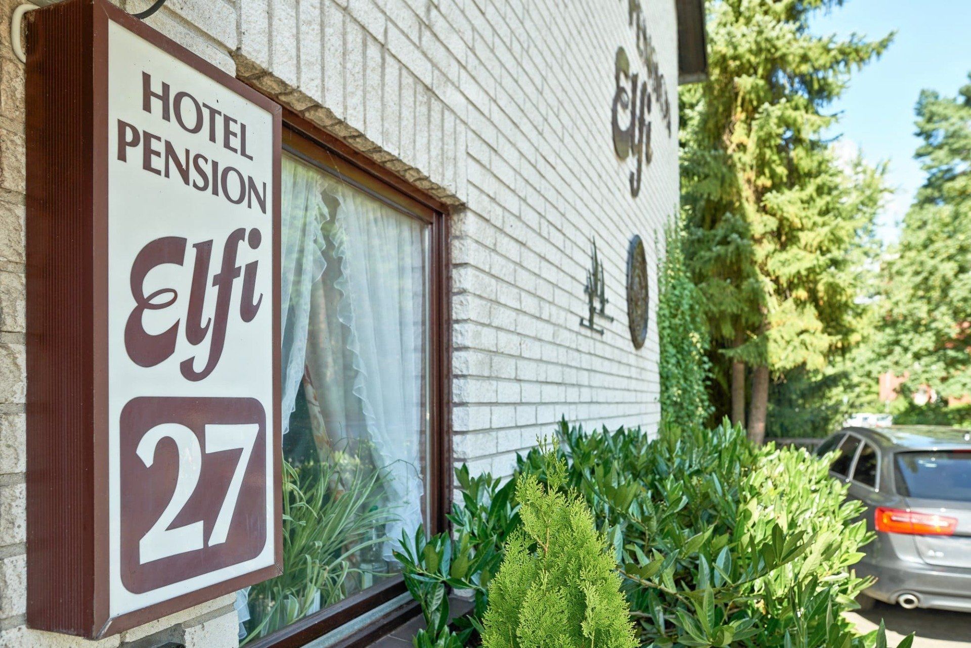 Ein Schild an der Seite eines Gebäudes mit der Aufschrift „Hotel Pension Elf 27“