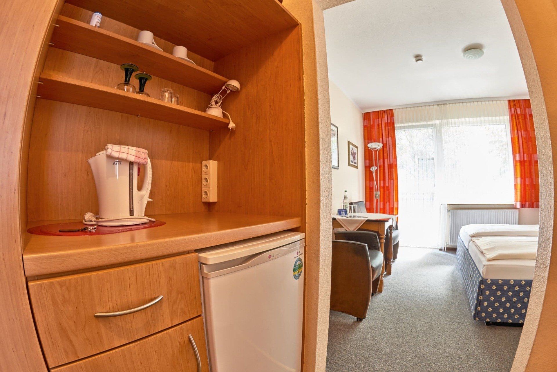 Ein Hotelzimmer mit Kühlschrank und Wasserkocher auf der Theke.