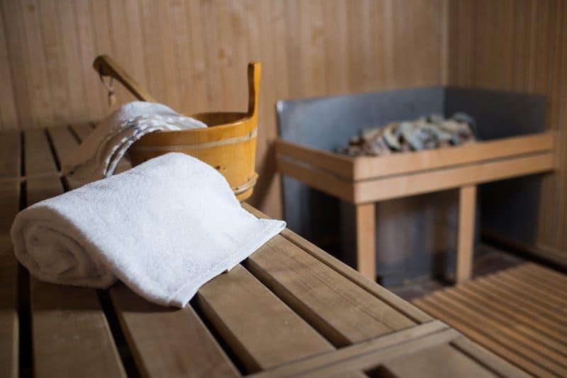 In einer Sauna liegt ein Handtuch auf einer Holzbank.