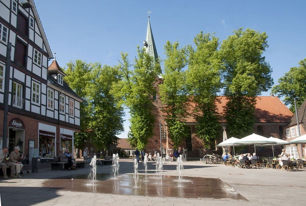 Ein Brunnen auf einem Platz mit einer Kirche im Hintergrund