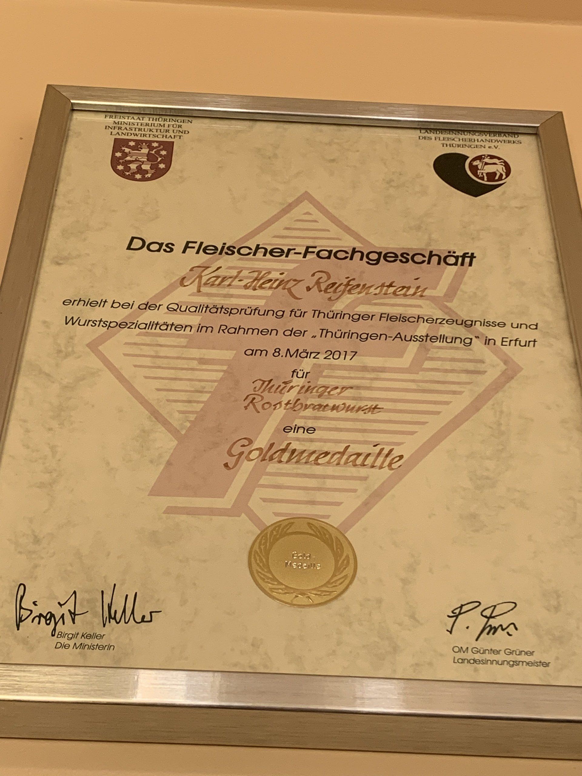 Eine gerahmte Urkunde mit einer Goldmünze darauf