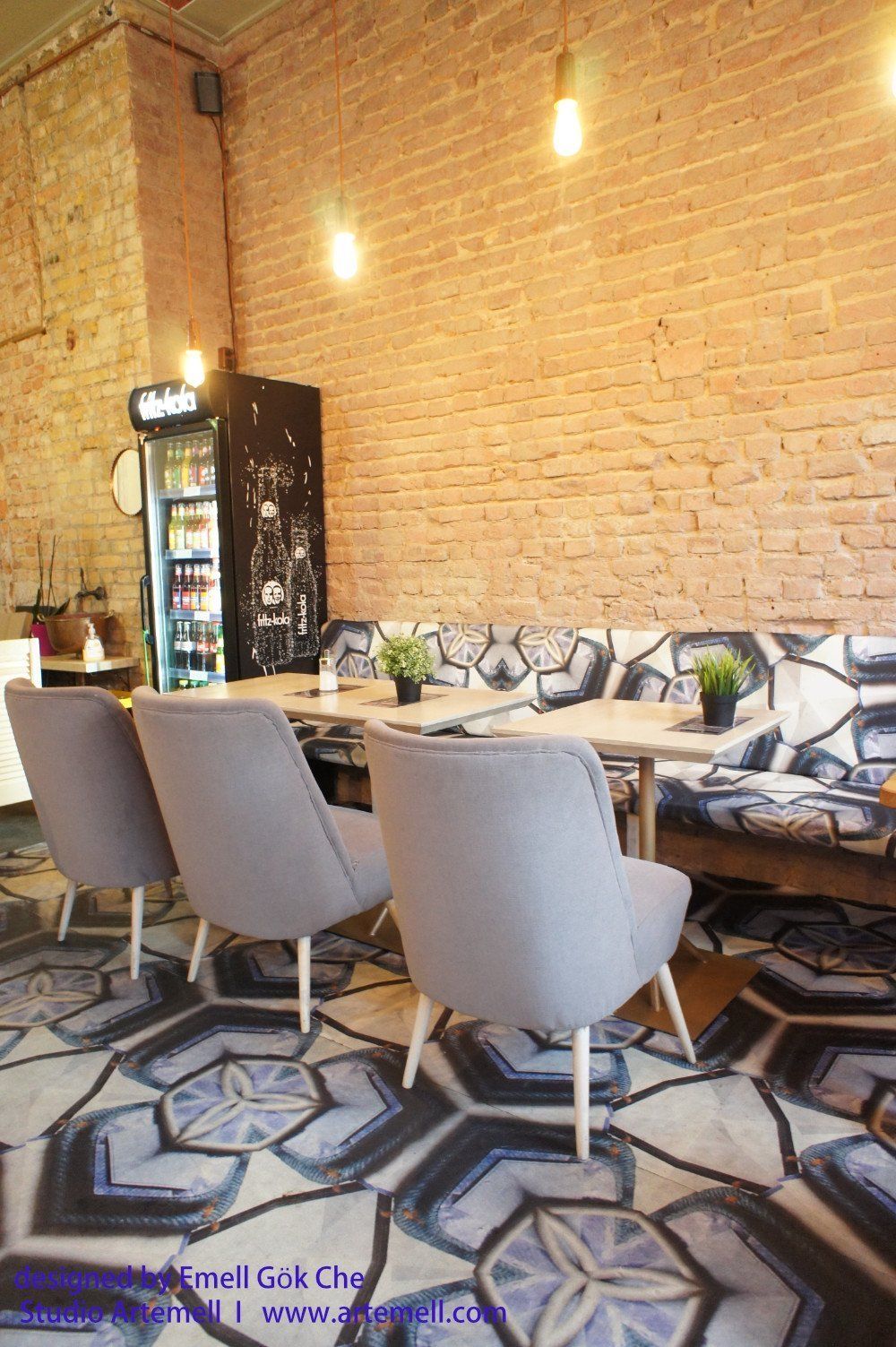Eine Reihe von Stühlen und Tischen in einem Restaurant mit einer Backsteinwand.