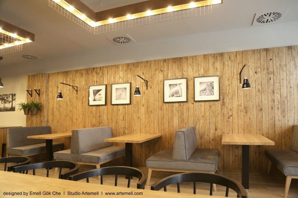 Ein Restaurant mit Holztischen und -bänken und einer Holzwand.