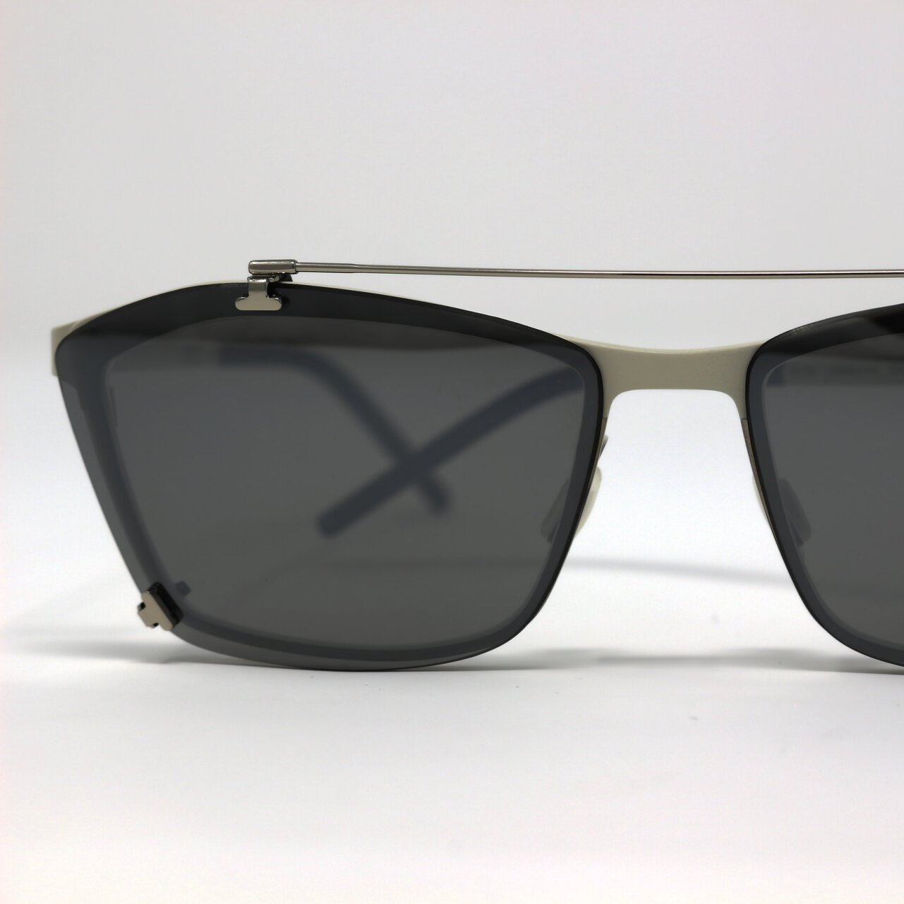 Close up of eClips 3 dark-lensed sunglass clip on silver metal frame