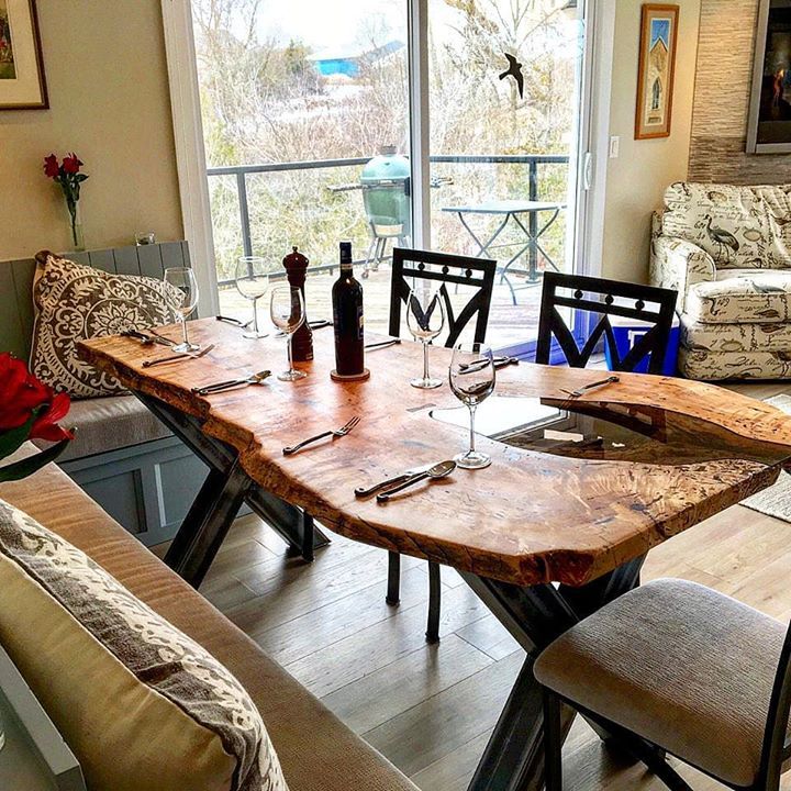 Natural edge dining table with rustic modern decor. Natural live edge reclaimed wood dining table with steel base.