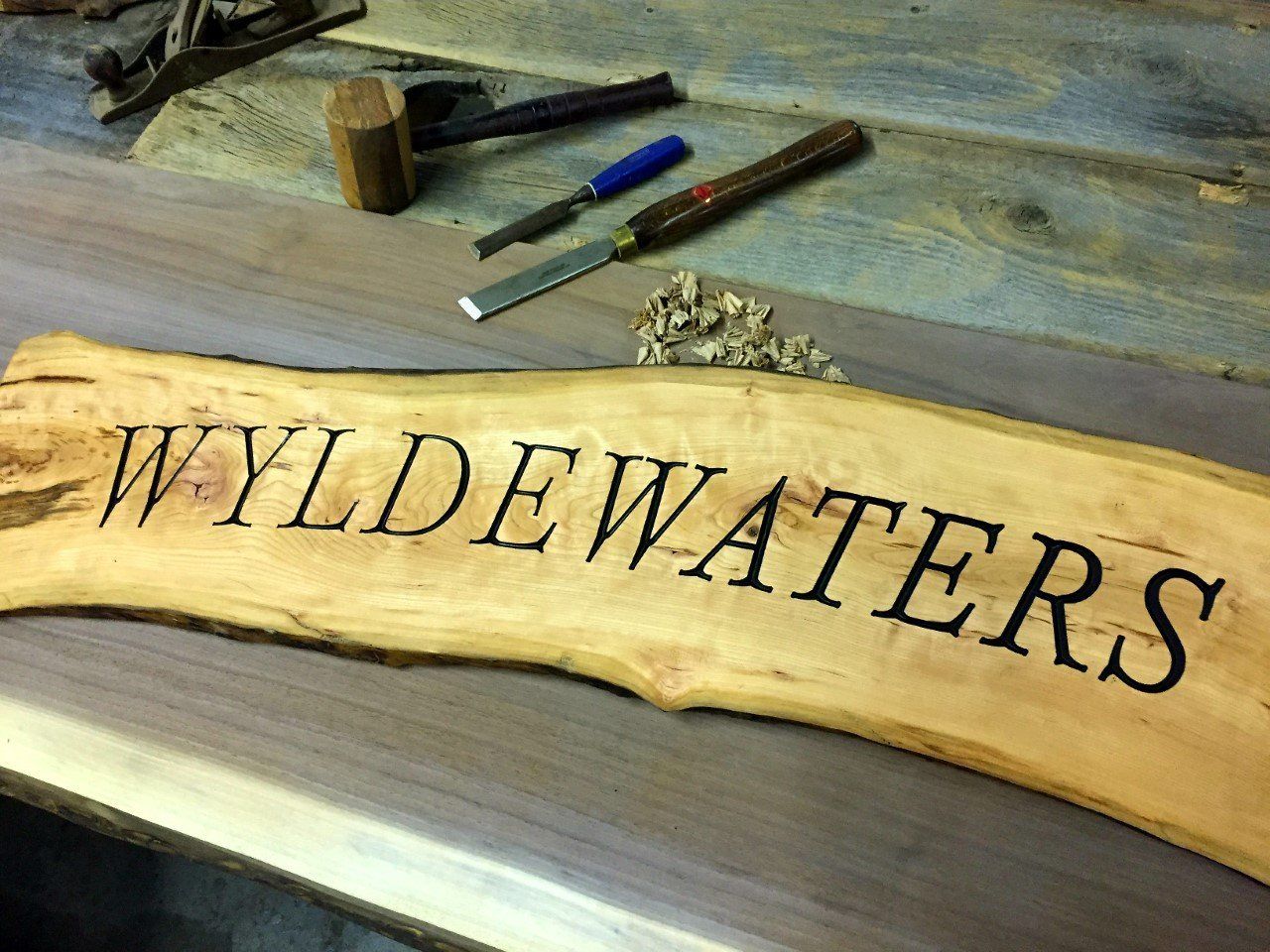 Cottage road sign carved on live edge wood.