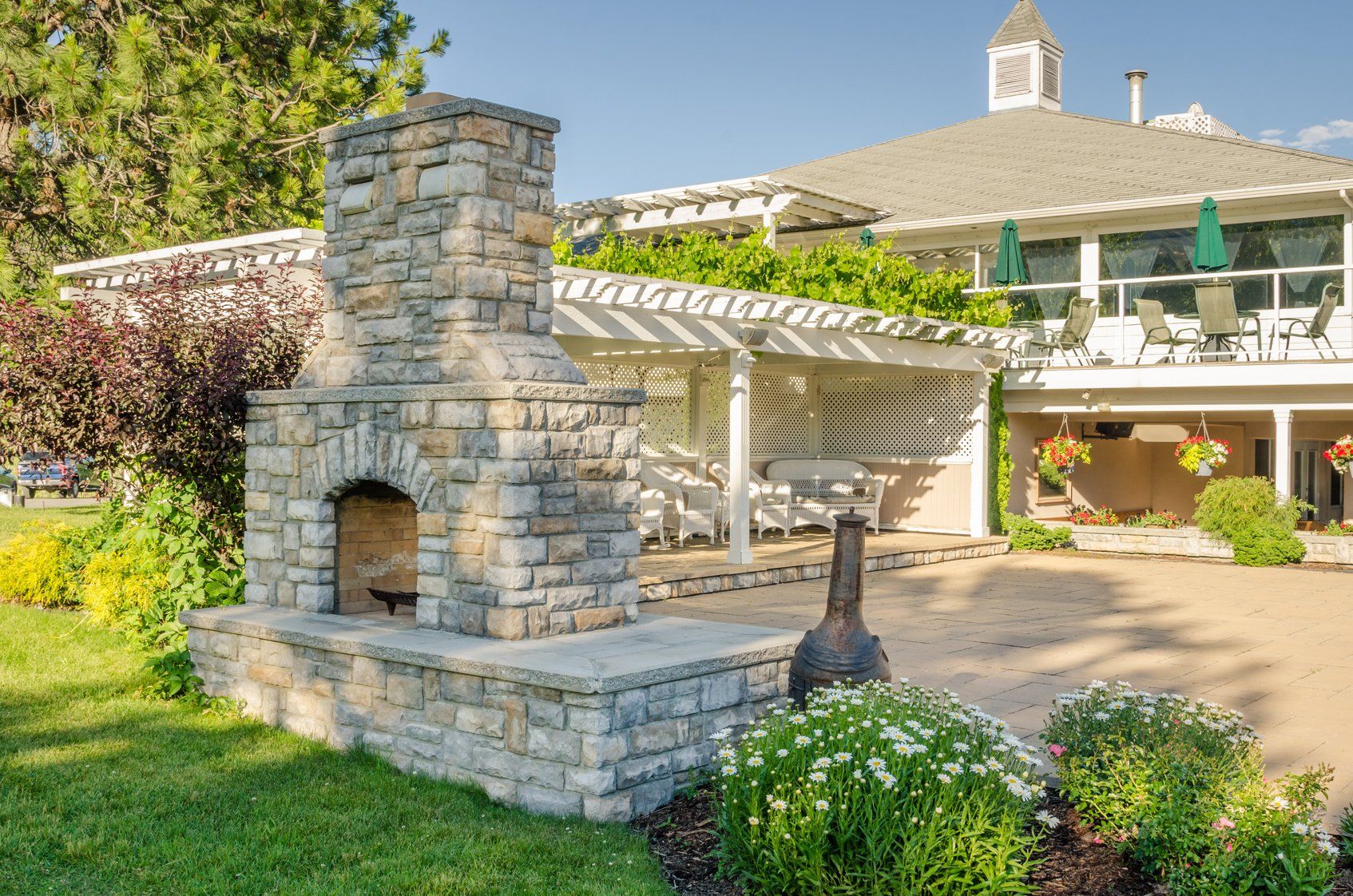There is a stone fireplace in the backyard of a house.