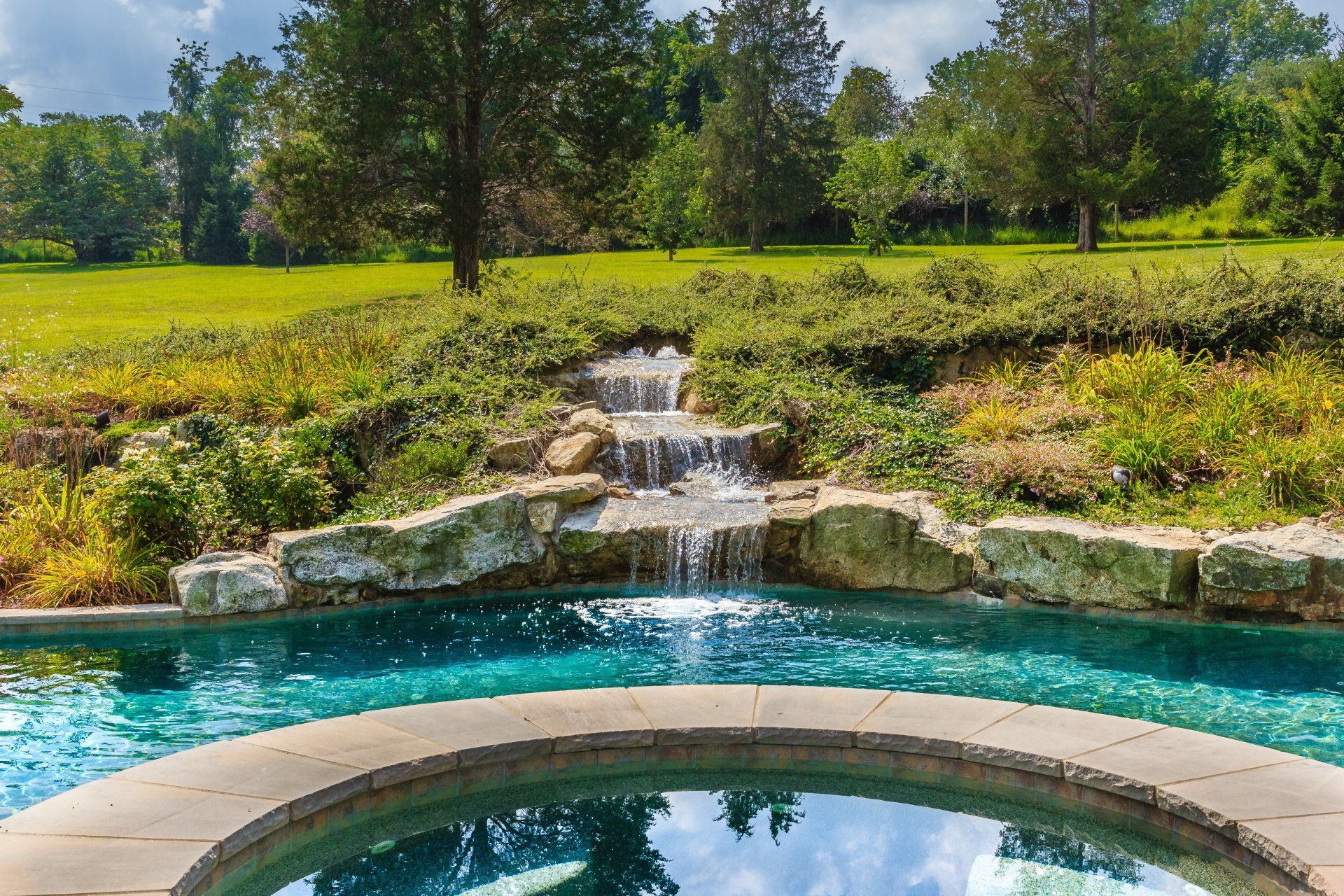 A swimming pool with a waterfall in the middle of it