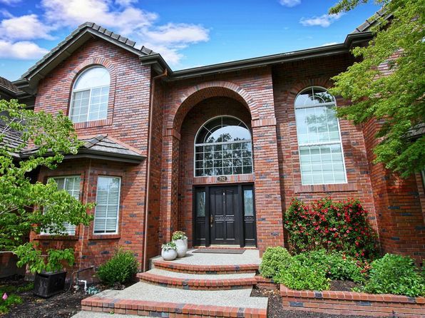 A large brick house with stairs leading up to the front door. Discover Rocklin's real estate with realtor, Sonia Immers