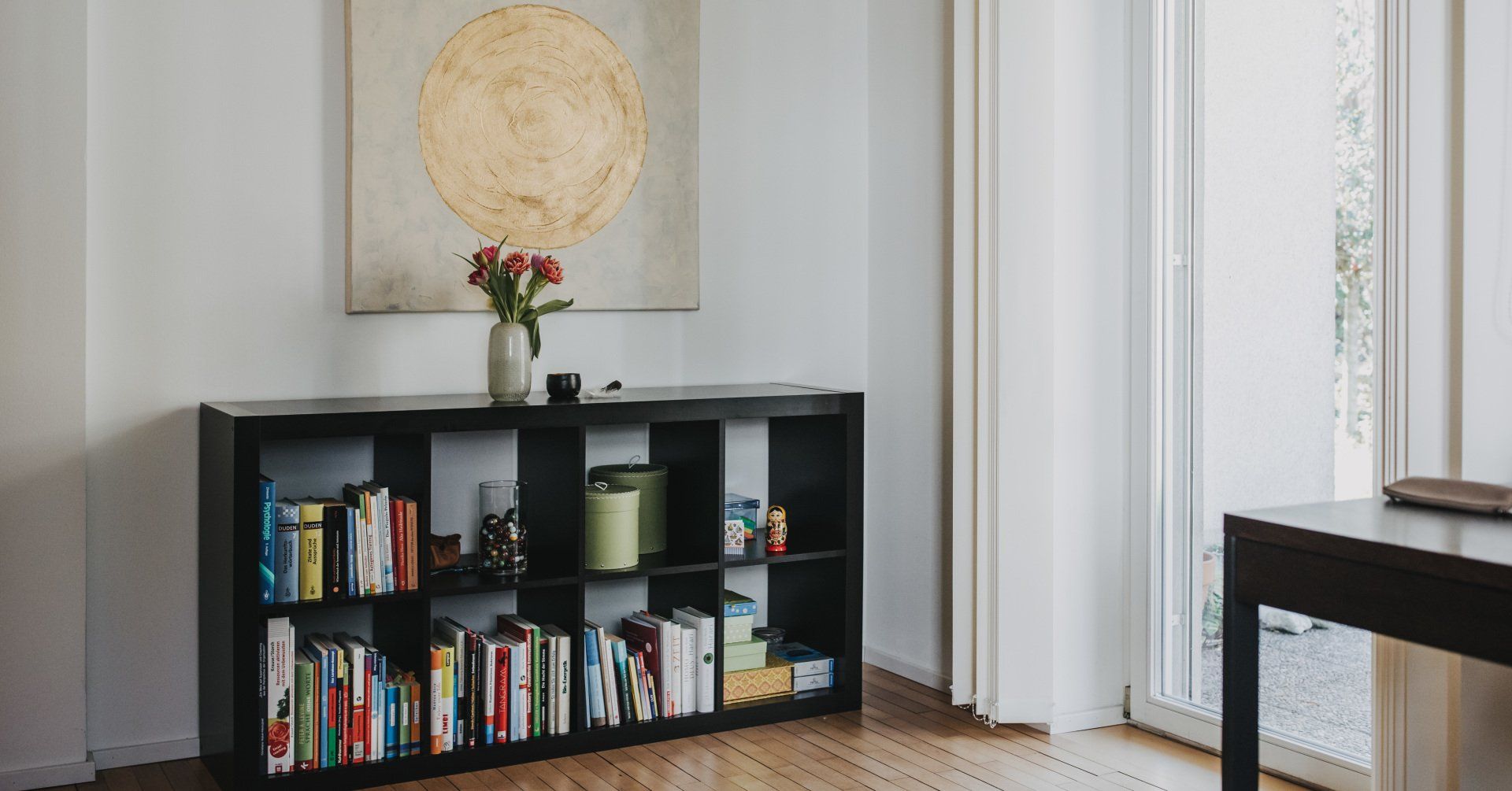 Ein Wohnzimmer mit einem Bücherregal voller Bücher und einem Tisch.