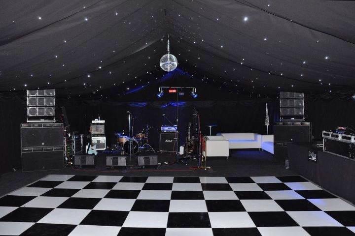 Black and white dance floor, stage with band equipment, starry ceiling, disco ball.