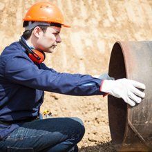 Catch & Basin — Man Inspecting Sewer Pipe in Bay City, MI Catch & Basin — Man Inspecting Sewer Pipe in Bay City, MI