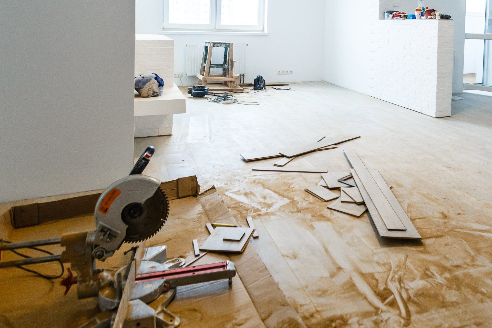 Circular saw and wood scraps on floor during renovation.