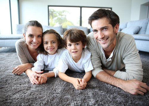 Carpet Restoration — Family at Home Relaxing on Clean Carpet in Flagstaff, AZ Carpet Restoration — Family at Home Relaxing on Clean Carpet in Flagstaff, AZ