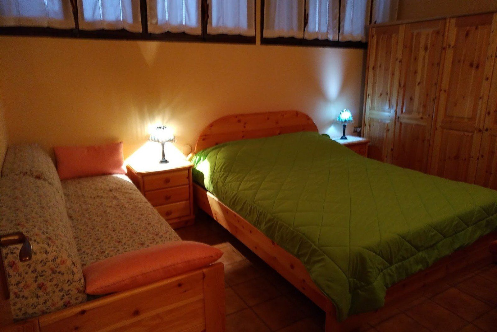 A bedroom with a double bed and a sofa.