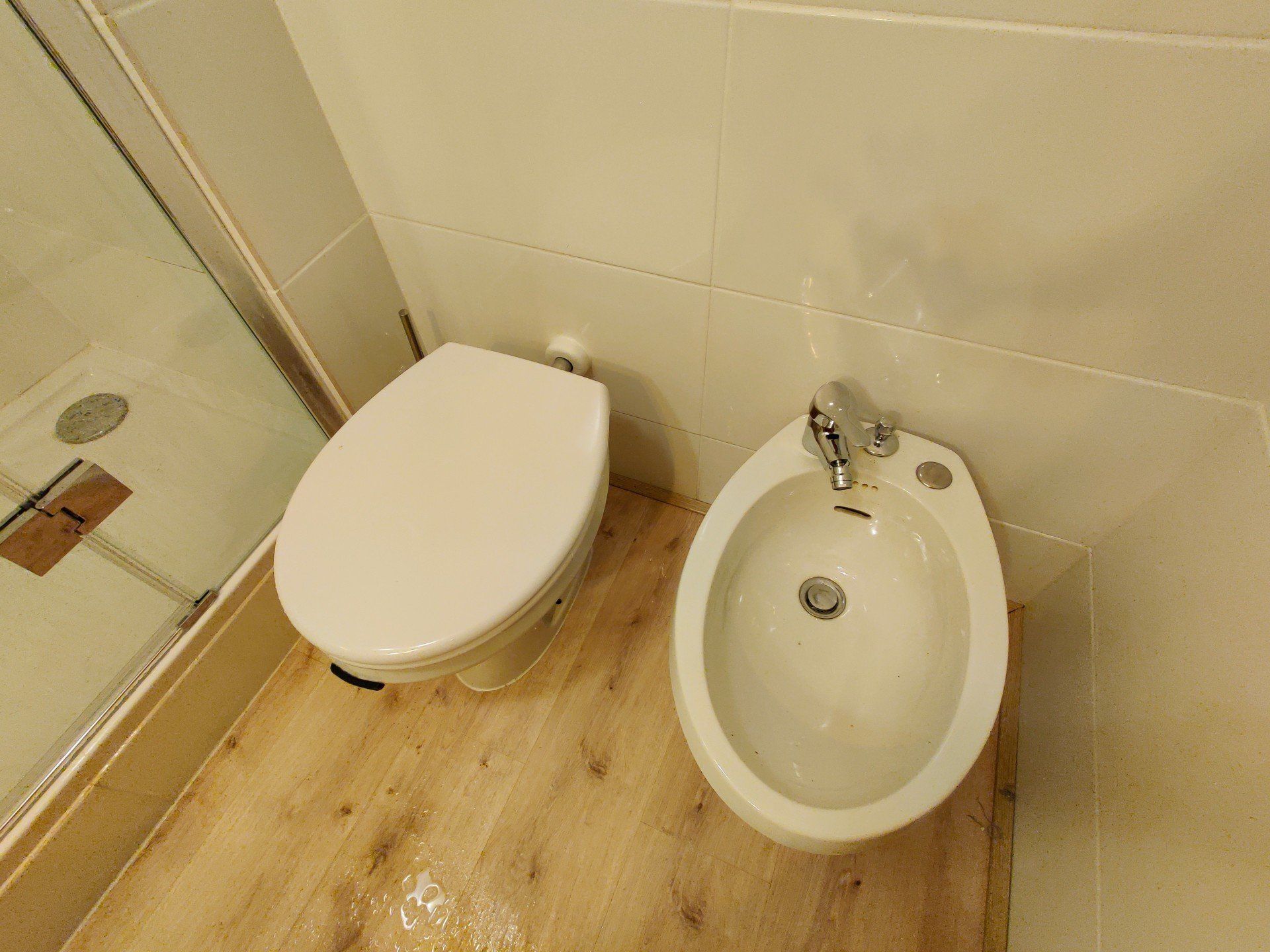 The toilet right next to a bidet